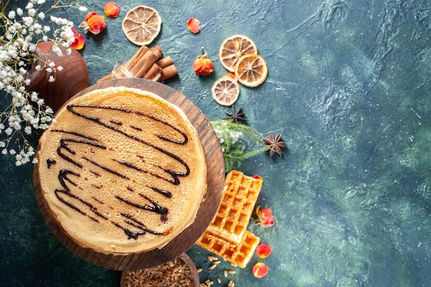 Вид сверху вкусные блины на темно-синем фоне медовый утренний пирог торт завтрак молочный десерт сладкий