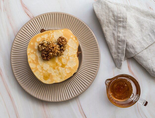 Top view tasty pancakes on a plate with honey