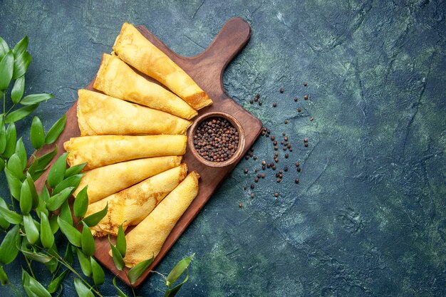 Top view tasty pancakes rolled with pepper on dark background pie meat pastry hotcake dough sweet cake meal color