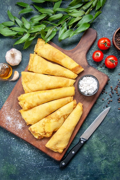 Foto gratuita vista dall'alto gustose frittelle arrotolate con pepe su sfondo scuro torta a base di carne pasta per hotcake pasta dolce colore