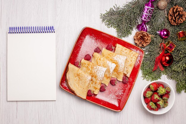 Top view of tasty pancakes with fruits on white