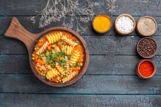 Top view tasty pasta soup from spiral italian pasta with different seasonings on dark desk soup color italian pasta dish cuisine