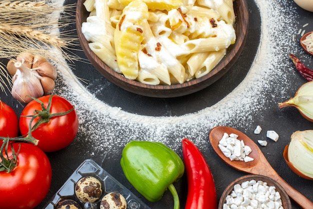 Free photo top view tasty penne pasta with potato in bowl tomatoes garlic peppers sea salt on table