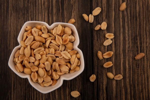 Top view of tasty pine nuts on a bowl with pine nuts isolated on a wooden table