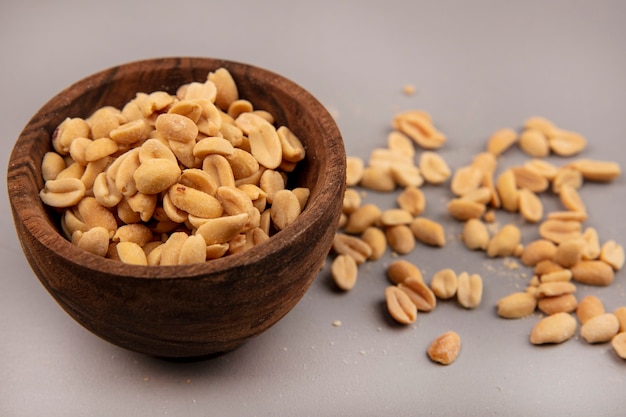 Top view of tasty pine nuts on a wooden bowl with pine nuts isolated