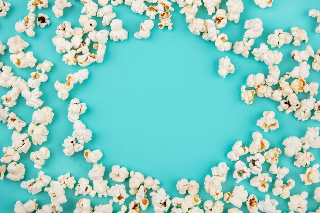 Top view of tasty popcorn isolated on blue surface