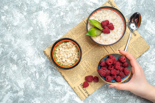 Top view of tasty porridge with raspberries on a light surface