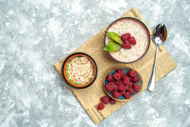 Top view of tasty porridge with raspberries on light surface