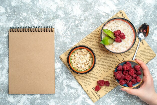 Top view of tasty porridge with raspberries on light surface