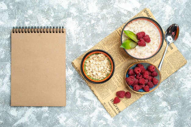 Top view of tasty porridge with raspberries on the light surface