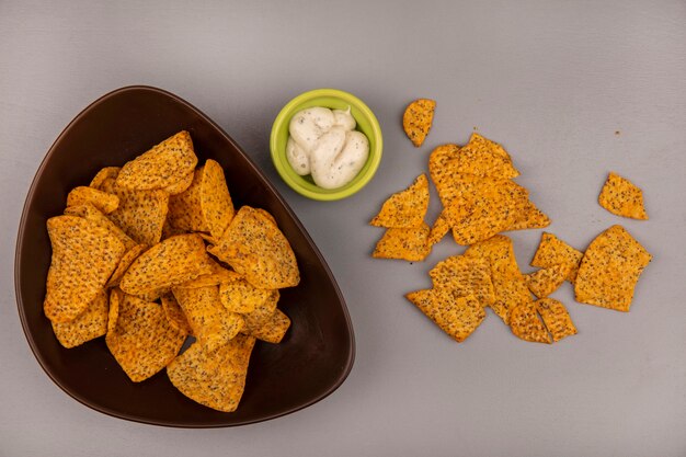 Top view of tasty potato chips on a bowl with sauce