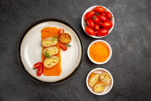Вид сверху вкусные картофельные пироги с тыквой и свежими помидорами на сером столе в духовке, испечь цветное блюдо, ломтик ужина