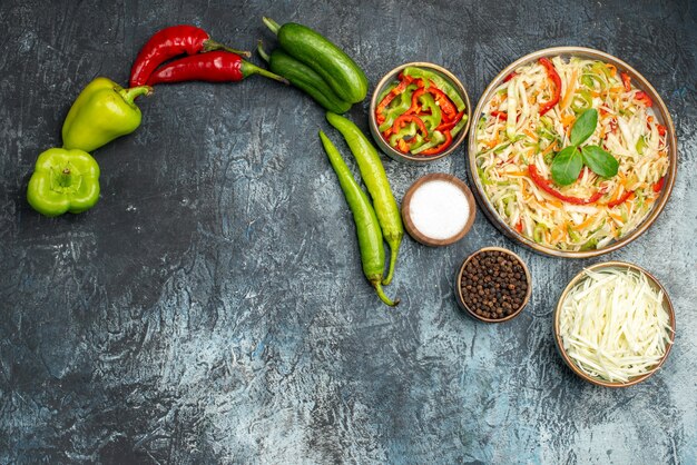 Top view of tasty salad with fresh vegetables on dark surface