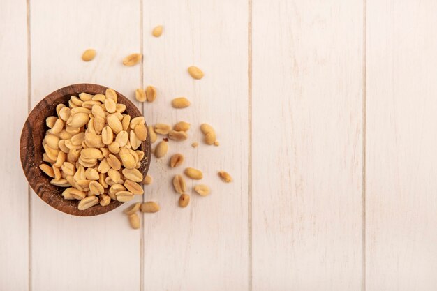 Top view of tasty salty pine cones on a wooden bowl on a beige wooden table with copy space