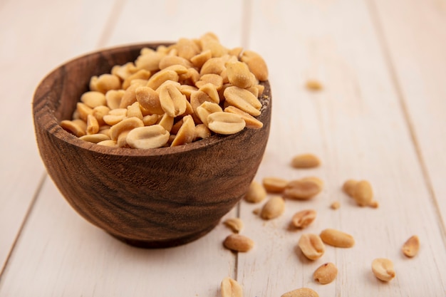 Free photo top view of tasty salty pine cones on a wooden bowl on a beige wooden table