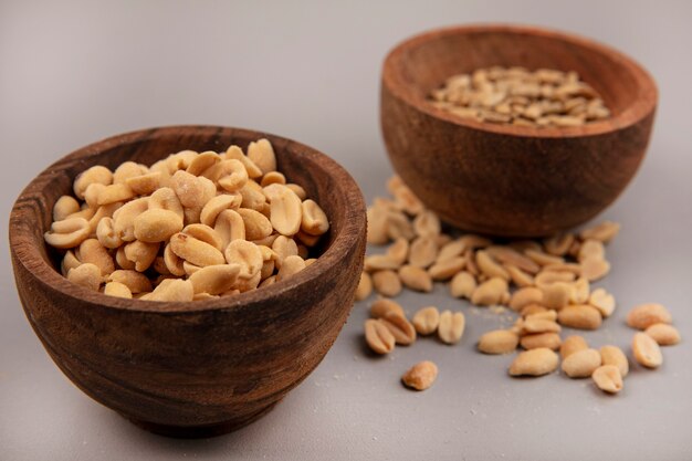 Top view of tasty and salty pine nuts on a wooden bowl with shelled sunflower seeds