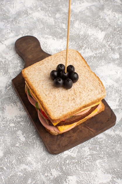Top view tasty sandwich with olive ham tomatoes vegetables on stick on the bright background sandwich food snack breakfast photo