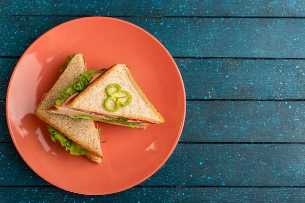 Free photo top view of tasty sandwiches with green salad ham and tomatoes