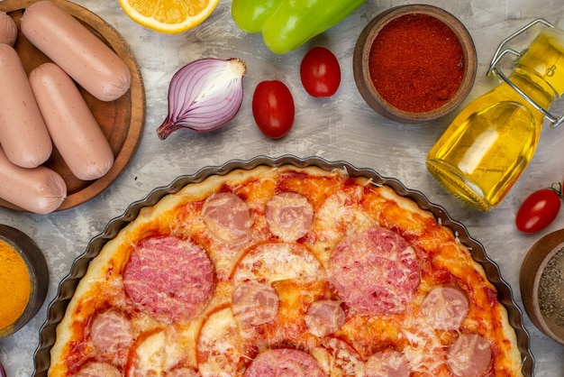 Foto gratuita vista dall'alto gustosa pizza con salsiccia con verdure fresche sul tavolo bianco cuocere al forno colore pasta torta pizza italia fast-food