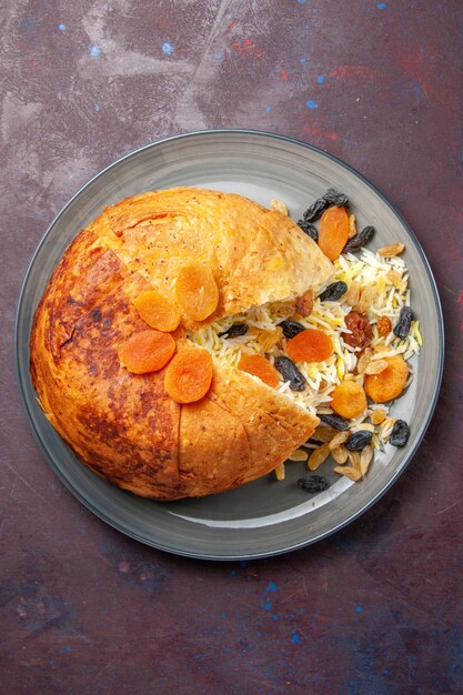 Top view of tasty shakh plov with raisins on dark surface