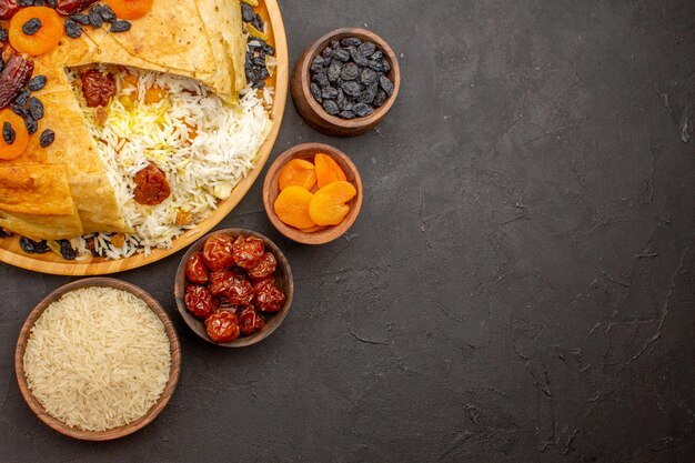 Top view of tasty shakh plov with raisins and dried apricots on dark surface