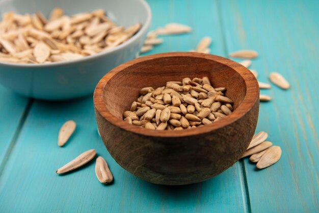 Top view of tasty shelled sunflower seeds on a wooden bowl