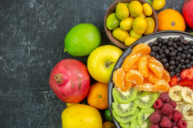 Вид сверху вкусные нарезанные фрукты со свежими овощами на сером фоне