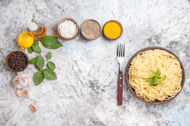 Top view tasty spaghetti with seasonings on white dough dish pasta