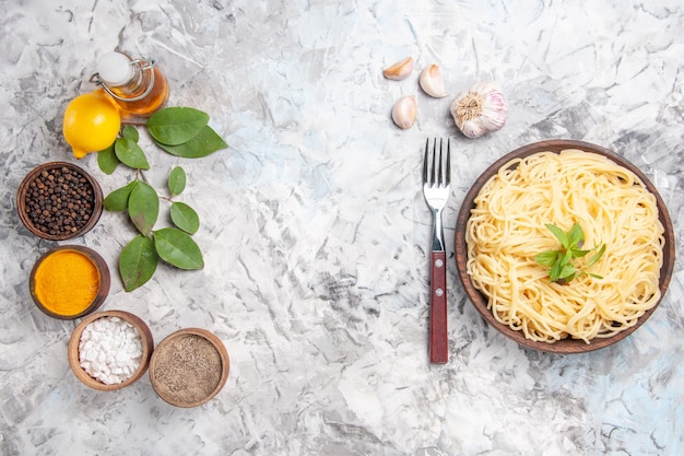 Top view tasty spaghetti with seasonings on the white dough meal dish pasta