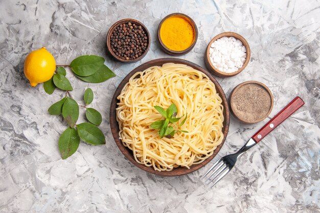 Top view tasty spaghetti with seasonings on white dough meal pasta dish