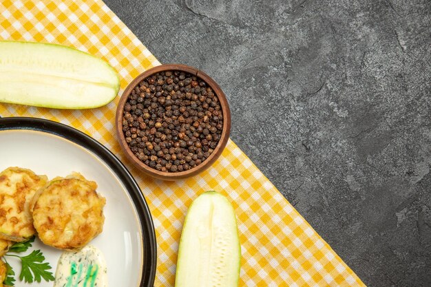 맛있는 스쿼시 식사의 상위 뷰는 회색 표면에 요리 야채를 슬라이스