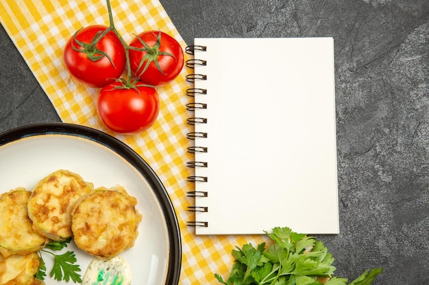 Top view of tasty squash meal sliced cooked vegetables with tomatoes on grey surface