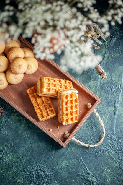 Top view tasty sweet biscuits with sweet little cakes on dark background color sweet cake pie sugar cookie nut