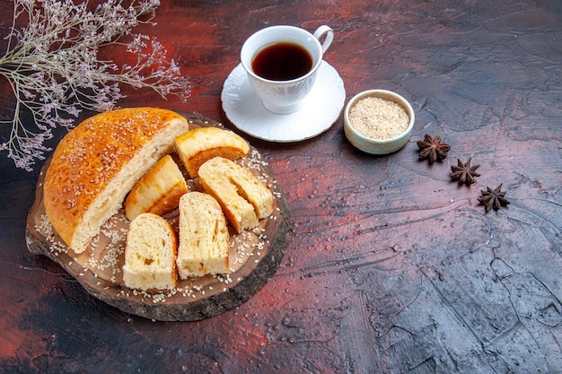 Free photo top view tasty sweet pastry sliced in pieces with tea on dark surface