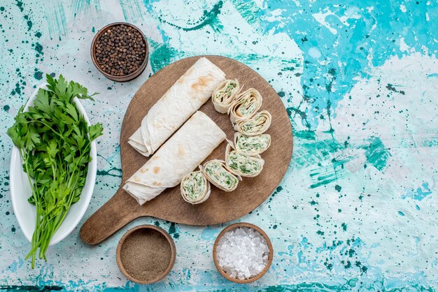 상위 뷰 맛있는 야채 롤 전체 및 밝은 책상 음식 식사 롤 야채에 채소 충전 및 조미료로 슬라이스