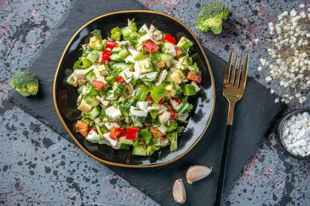 上面図おいしい野菜サラダは、暗い背景のプレート内のキュウリチーズとトマトで構成されています健康ダイエットカラーランチ食事料理料理