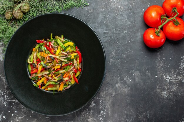 Top view of tasty vegetable salad on dark surface