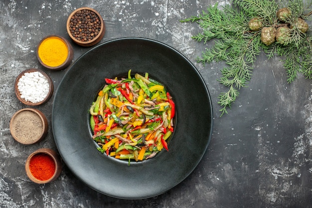 Top view of tasty vegetable salad on dark surface