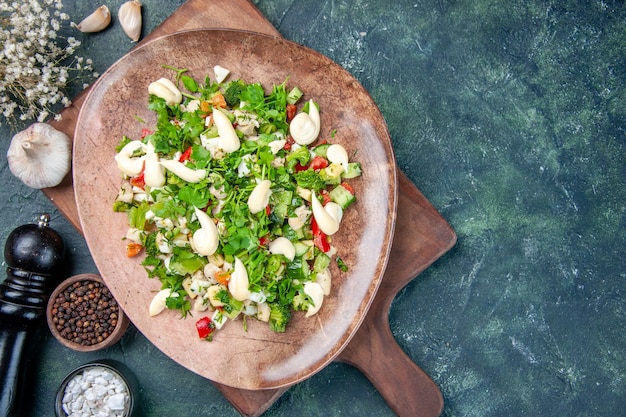 вид сверху вкусный овощной салат внутри тарелки на темно-синем фоне ресторан кухня ужин обед здоровое питание цвета кухня еда