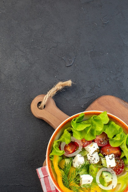 Free photo top view tasty vegetable salad with cheese cucumbers and tomatoes on dark background