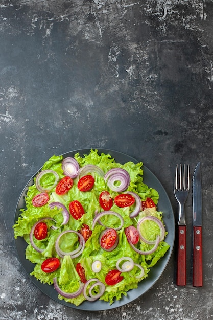 Top view tasty vegetable salad with onions green salad and tomatoes on a gray background photo food color salad health diet meal ripe