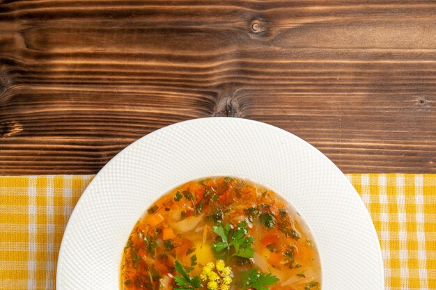 Top view tasty vegetable soup with greens on brown wooden table soup food vegetable seasoning