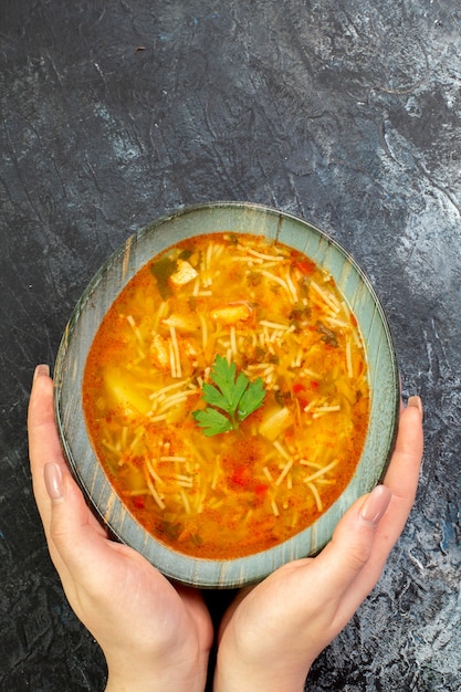 Top view of delicious vermicelli soup in a plate on a light-grey table