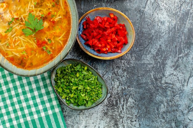 Top view tasty vermicelli soup with greens on light-grey table