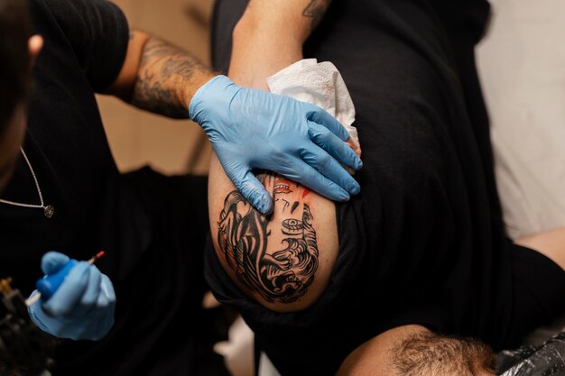 Художник-татуировщик в перчатках, вид сверху