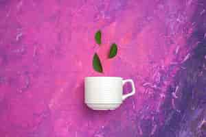 Бесплатное фото Вид сверху чайная чашка с листьями на розовом