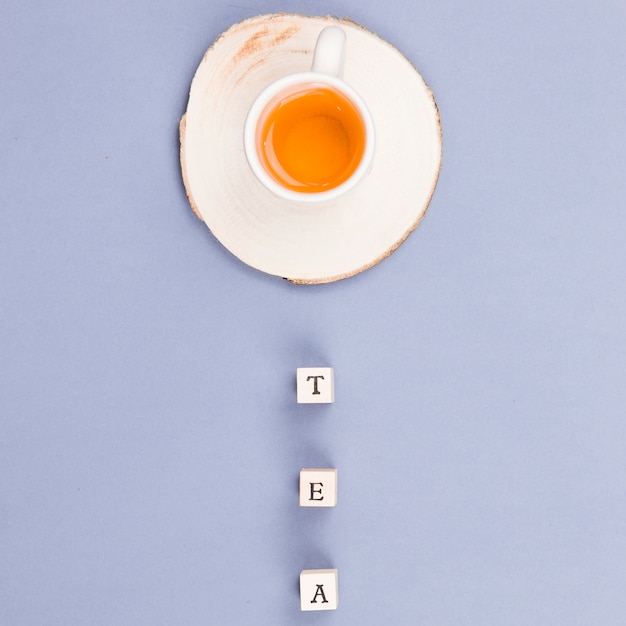 Бесплатное фото Чашка чая сверху с буквами кубиками