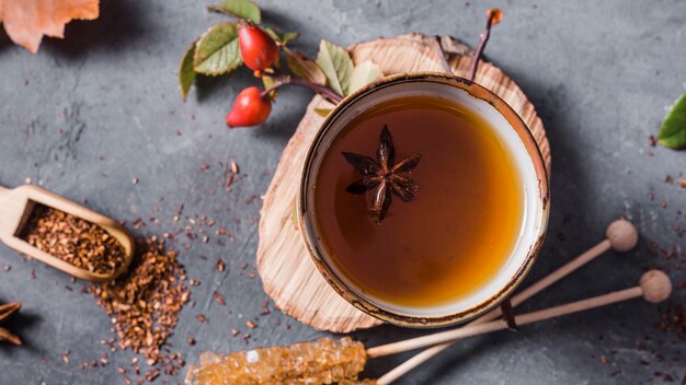 Top view tea in cup with star anise and crystallized sugar and cinnamon