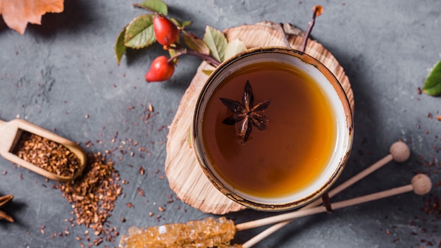 Top view tea in cup with star anise and crystallized sugar and cinnamon