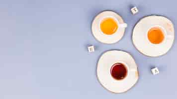 Free photo top view tea cups with letter dices